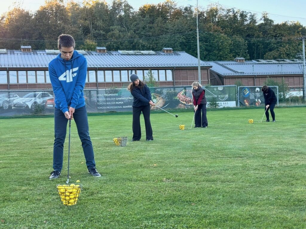 Studenci podczas treningu golfa.